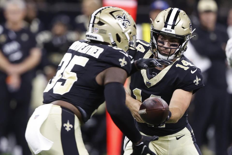 New Orleans Saints quarterback Jake Haener (14) hands off the ball to running back Ellis Merriweather (35) in the second half of a preseason NFL football game in New Orleans, Sunday, Aug. 13, 2023. (AP Photo/Butch Dill)