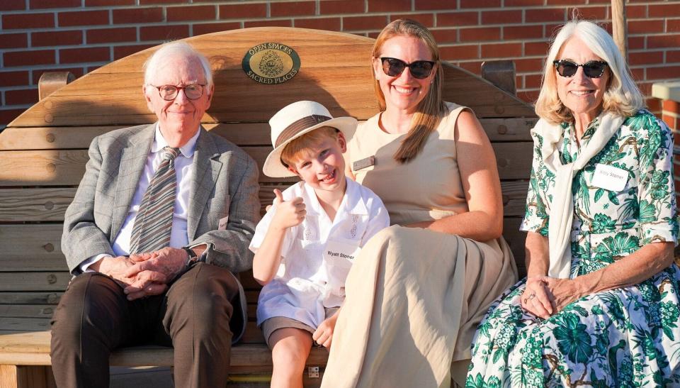 The Stoner family sits on the Nature Sacred bench at the Community Foundation of Greater Des Moines. Tom Stoner and his wife, Kitty, founded the nonprofit Nature Sacred to bring green spaces to places in need of the healing power of nature. From left are Stoner; Wyatt Stoner, his grandchild; and Alden Stoner, his daughter, who is now the CEO of Nature Sacred.