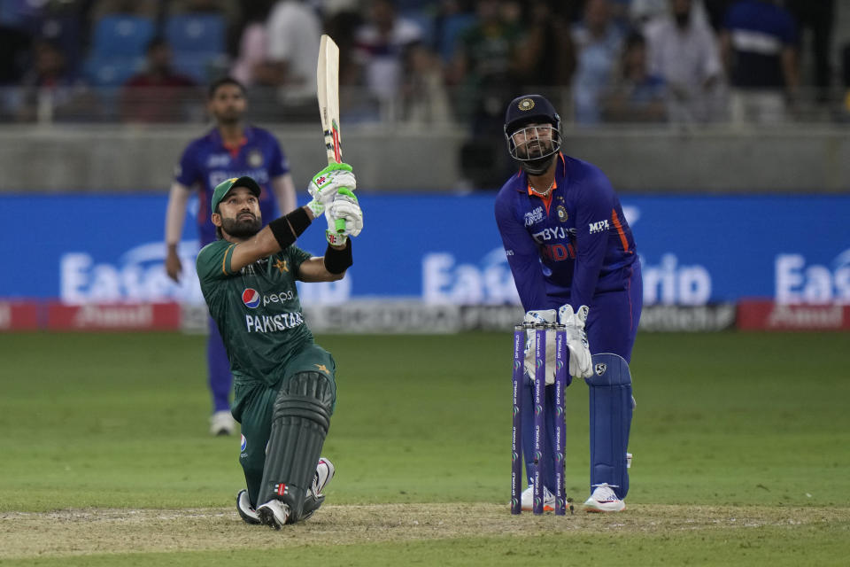 Pakistan's Mohammad Rizwan, left, follows the ball after playing a shot during the T20 cricket match of Asia Cup between India and Pakistan, in Dubai, United Arab Emirates, Sunday, Sept. 4, 2022. (AP Photo/Anjum Naveed)