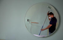Hotel maintenance worker Elgis Moreno is reflected on a mirror as he paints a room at the Capri Hotel, during a lockdown affecting tourism to curb the spread of the new coronavirus in Havana, Cuba, Wednesday, June 17, 2020. Foreign hospitality companies that manage most of the better hotels say they are hopeful to see tourists return at the latter stages of the country's opening plan, and Cuba says more normal tourism will return to the island by phase 3 with near-universal mask-wearing, social distancing, and COVID-19 tests for arriving travelers. (AP Photo/Ismael Francisco)
