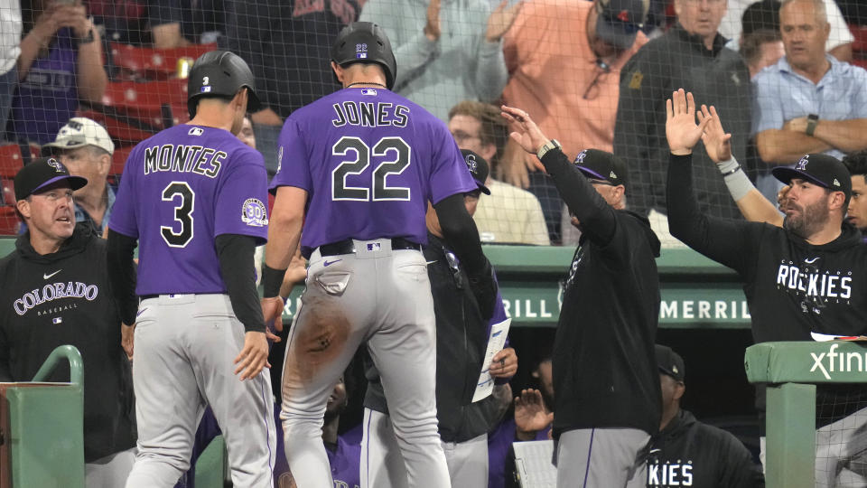 Colorado Rockies' Coco Montes (3) and Nolan Jones (22) are congratulated after scoring on a two RBI double by Randal Grichuk in the tenth inning during a baseball game against the Boston Red Soxat Fenway Park, Tuesday, June 13, 2023, in Boston. (AP Photo/Charles Krupa)