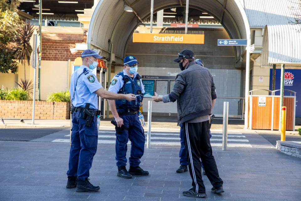 Police officers talk to a man for not wearing a mask at Strathfield station in Sydney, Australia. 