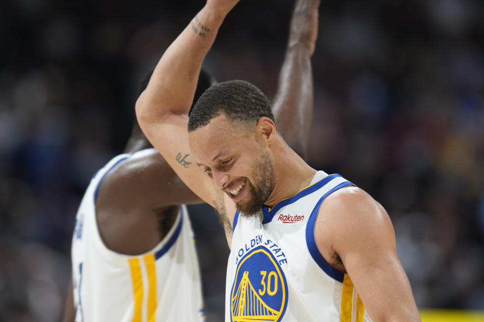 Golden State Warriors guard Stephen Curry, front, congratulates forward Draymond Green near the endoof Game 3 of the team's NBA basketball first-round Western Conference playoff series against the Denver Nuggets Thursday, April 21, 2022, in Denver. (AP Photo/David Zalubowski)