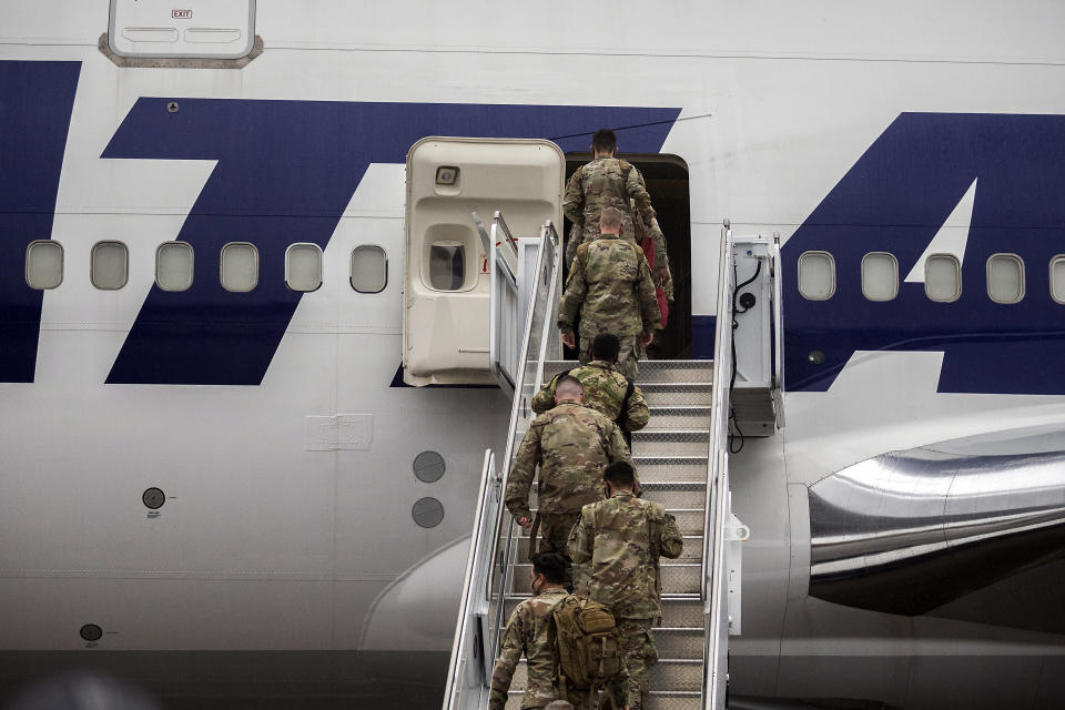 A group of soldiers with the U.S. Army's 87th Division Sustainment Support Battalion, 3rd Division Sustainment Brigade, board a chartered plane during their deployment to Europe, Friday, March 11, 2022, at Hunter Army Airfield in Savannah, Ga. The unit is attached to the Army's 3rd Infantry Division out of Fort Stewart, Ga., and will join the 3,800 troops already deployed in support of NATO in Eastern Europe. (AP Photo/Stephen B. Morton)