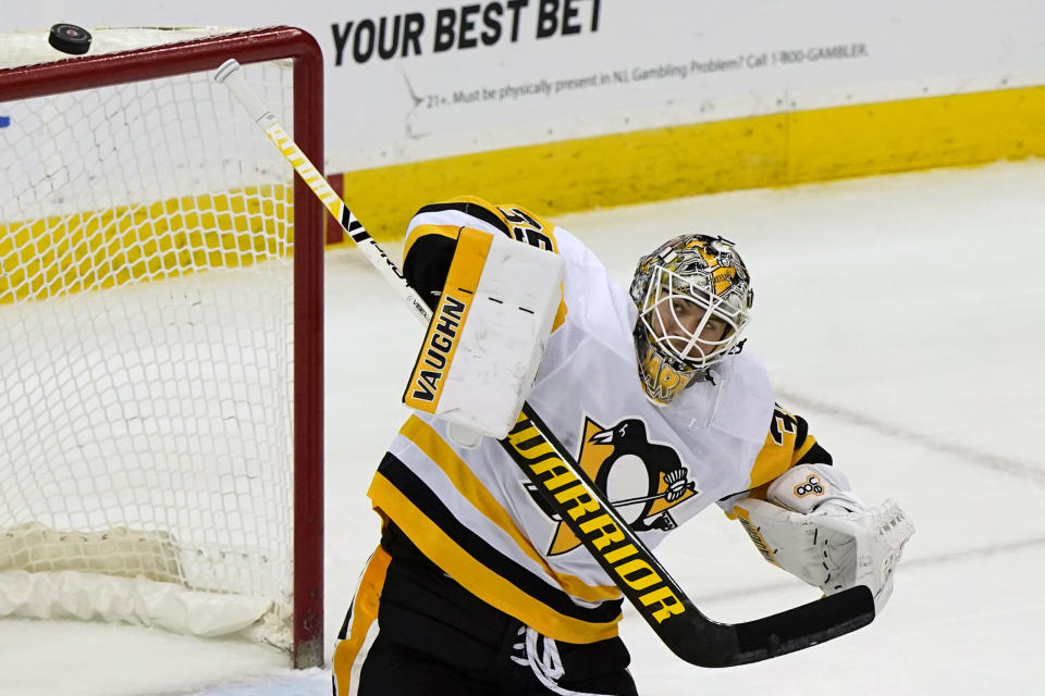 Pittsburgh Penguins goaltender Tristan Jarry (35) deflects the puck during the third period of an NHL hockey game against the New Jersey Devils, Sunday, April 11, 2021, in Newark, N.J. (AP Photo/Kathy Willens)