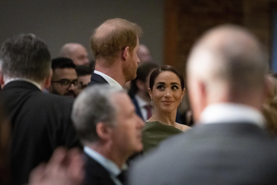 Meghan Markle smiles at Prince Harry during the "One Year to Go" Invictus Games dinner in Vancouver, British Columbia, Friday, Feb. 16, 2024. (Ethan Cairns/The Canadian Press via AP)