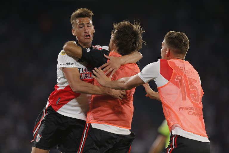 El 2-0 de fue marcado por Braian Romero, que jugó para la causa: actuó como una suerte de número 8; aquí, lo abraza Ponzio, un símbolo en el banco de los suplentes (Photo by DIEGO LIMA / AFP)