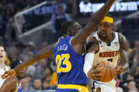 Denver Nuggets guard Kentavious Caldwell-Pope, right, passes the ball while defended by Golden State Warriors forward Draymond Green (23) during the first half of an NBA basketball game in San Francisco, Friday, Oct. 21, 2022. (AP Photo/Jeff Chiu)