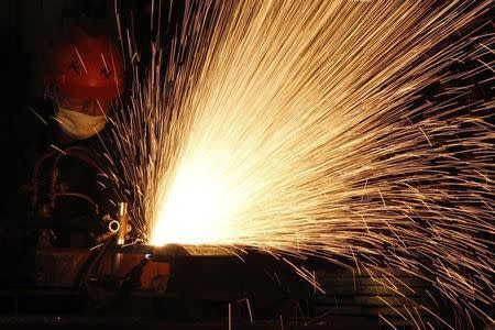 A worker cuts a steel plate at a workshop of the Electro-Mechanical Equipment Co, Ltd. in Huaibei, Anhui province April 29, 2010. REUTERS/Stringer