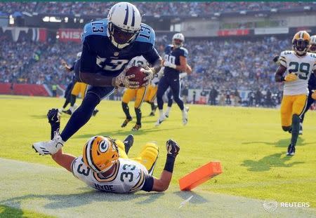 Nov 13, 2016; Nashville, TN, USA; Tennessee Titans wide receiver Kendall Wright (13) scores after a reception before being hit out of bounds by Green Bay Packers defensive back Micah Hyde (33) during the first half at Nissan Stadium. Mandatory Credit: Christopher Hanewinckel-USA TODAY Sports