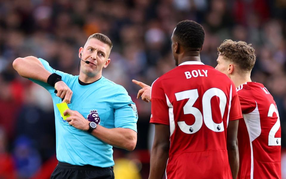 Match Referee Robert Jones shows a second yellow card to Willy Boly of Nottingham Forest, resulting in a red card, during the Premier League match between Nottingham Forest and AFC Bournemouth at City Ground on December 23, 2023