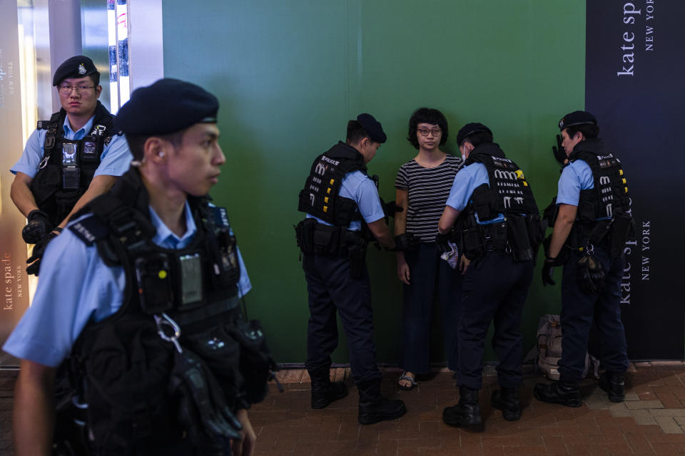 Police officers conduct a search on a member of the public in the Causeway Bay area on the eve of the 34th anniversary of China's Tiananmen Square massacre, in Hong Kong, Saturday, June 3, 2023. (AP Photo/Louise Delmotte)