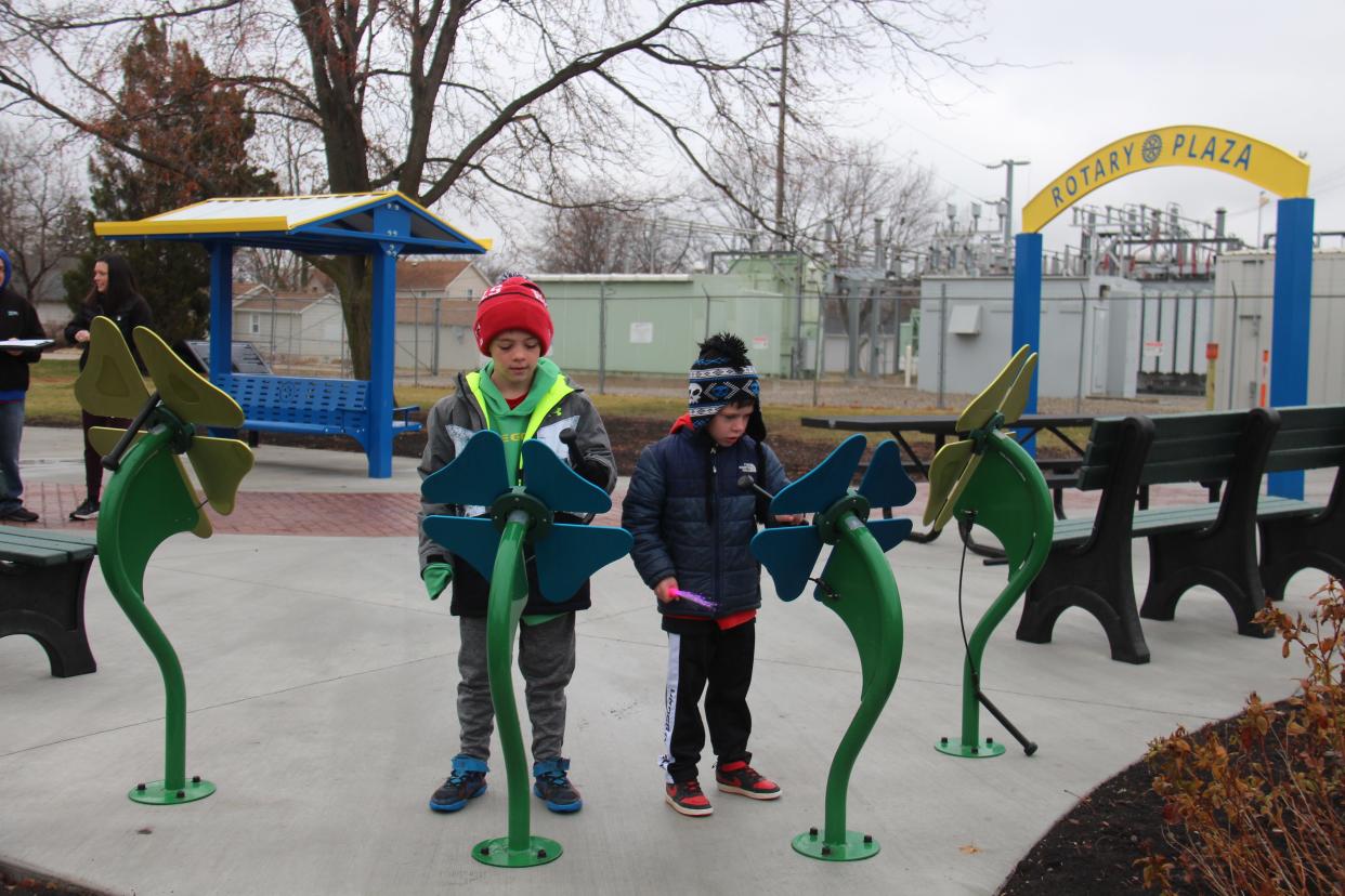 Talon (8) and Tyler (6) Karns play a song on the interactive musical flowers in the newly renovated Rotary Plaza in Adel.