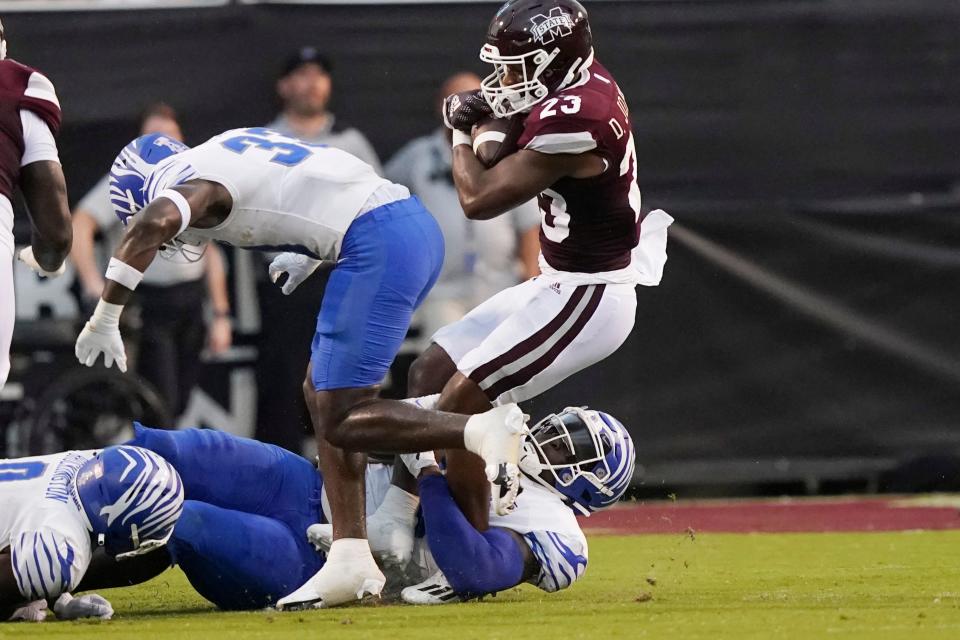 Mississippi State running back Dillon Johnson (23) twists as he is tackled by a Memphis defensive player after a short gain during the first half of an NCAA college football game in Starkville, Miss., Saturday, Sept. 3, 2022. (AP Photo/Rogelio V. Solis)