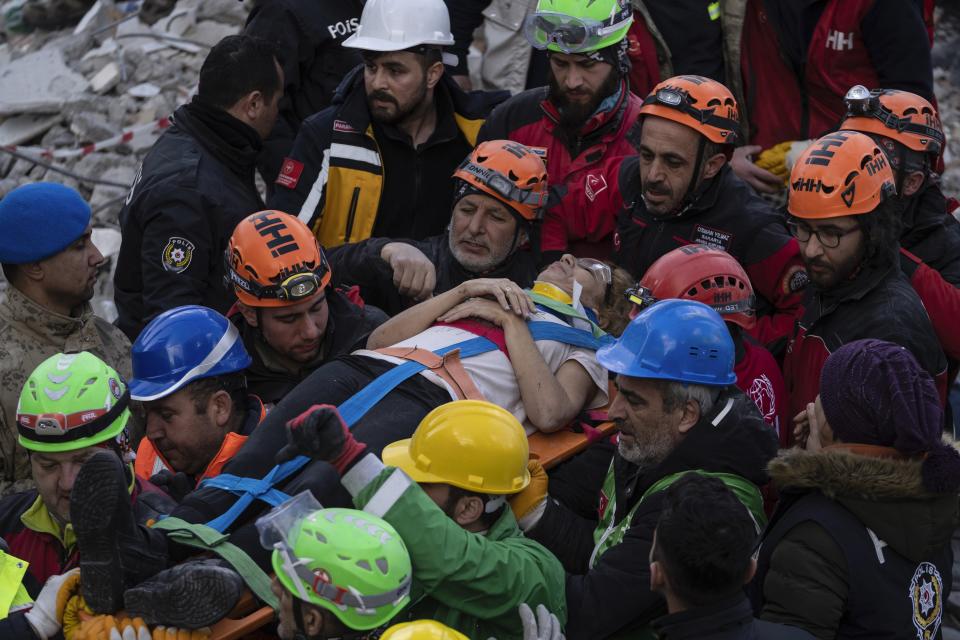 Raziye Kilinc is carried through a crowd on a stretcher after she was rescued under a destroyed building in Iskenderun, southeastern Turkey, Friday, Feb. 10, 2023. A married couple was pulled from beneath the rubble of a collapsed building in Iskenderun after spending 109 hours buried within a small crevice. (AP Photo/Petros Giannakouris)
