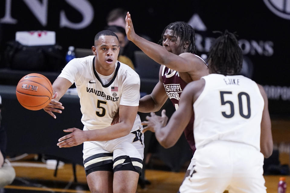 Vanderbilt guard D.J. Harvey (5) passes the ball to Ejike Obinna (50) as Harvey is defended by Mississippi State guard Cameron Matthews (4) in the second half of an NCAA college basketball game Saturday, Jan. 9, 2021, in Nashville, Tenn. (AP Photo/Mark Humphrey)