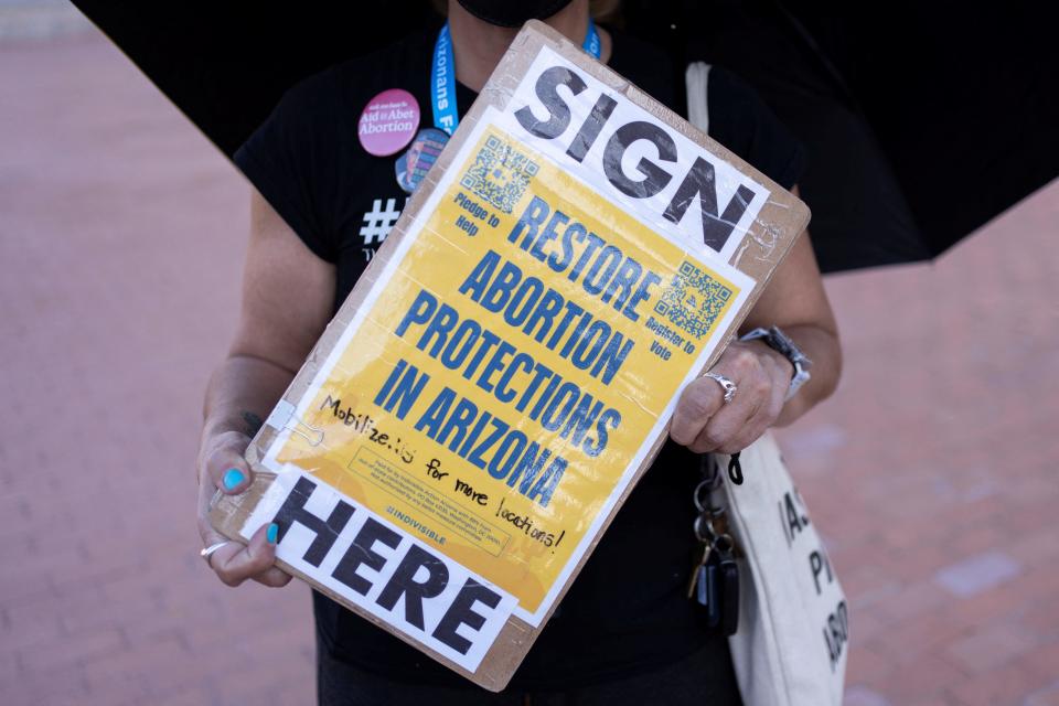 An organizer carries a clipboard with petitions for a ballot initiative to enshrine abortion into the Arizona state constitution in Tucson, Arizona, on April 9, 2024.