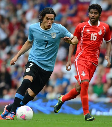 Goleador de la selección de Uruguay Edinson Cavani (I) disputa el balón con Rashed Eisa de Emiratos Arabes Unidos en el partido debut de su serie en los Juegos Olímpicos de Londres el 26 de julio de 2012 en Old Trafford, Manchester.- (AFP | andrew yates)