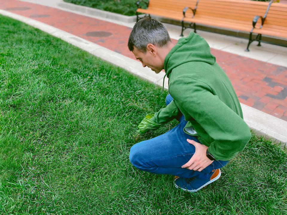 A man picking up their pet's poop