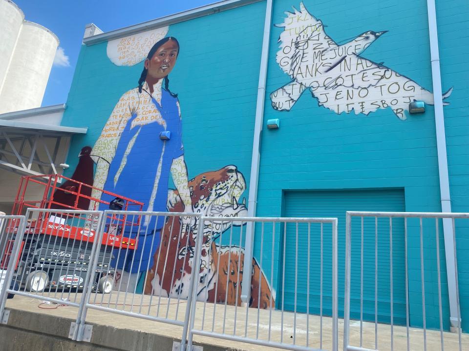 Kansas City artist Isaac Tapia painted a mural of an indigenous Hispanic woman and several animals at the MIDXMIDWST mural arts and culture festival.