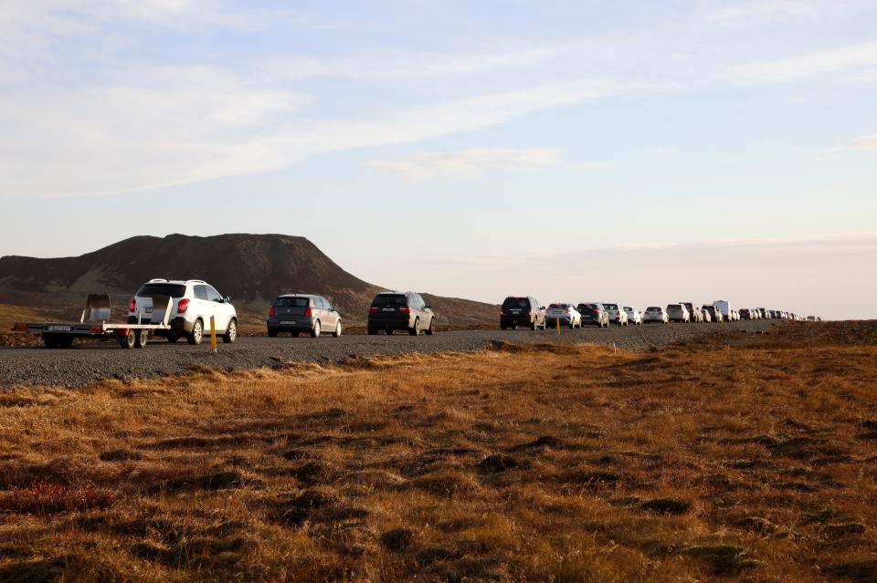 A line of cars queued on a road heading to the town of Grindavik, Iceland on Monday as residents were briefly allowed to return to their homes (AP)