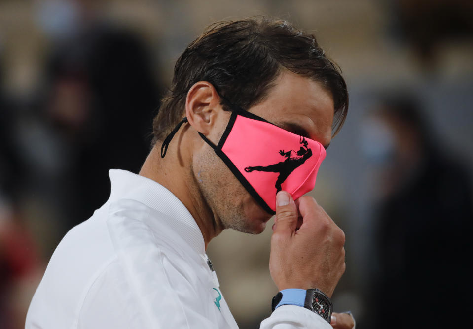 Nadal emocionado tapándose los ojos con la mascarilla. (AP Foto/Christophe Ena)