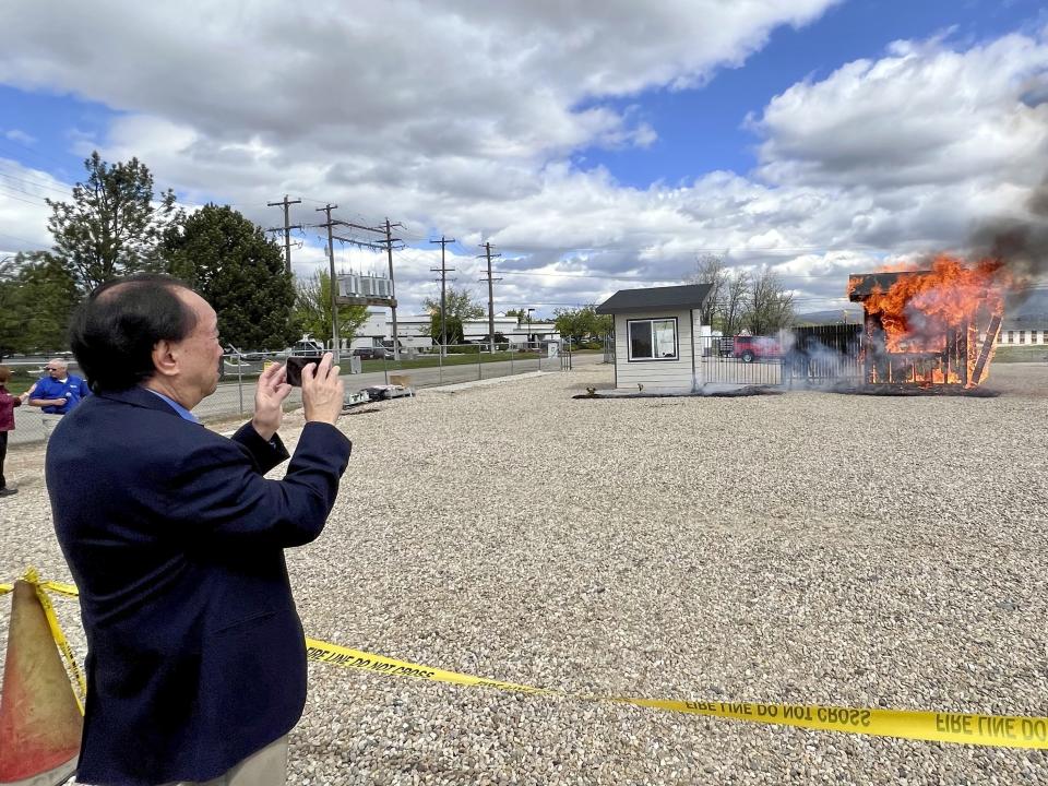 Hawaii Insurance Commissioner Gordon Ito films a wildfire burn risk demonstration at the National Interagency Fire Center in Boise, Idaho, Monday, April 29, 2024. Some property insurance companies in Hawaii and other states have stopped providing coverage to residents because of increasing wildfire risk and climbing construction costs. The Idaho Department of Insurance hosted the burn demonstration as part of a forum for western Insurance commissioners on the impact wildfires are having on the nation’s insurance market. (AP Photo/Rebecca Boone)