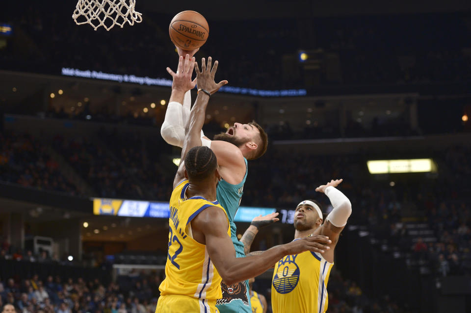 Memphis Grizzlies center Jonas Valanciunas, top, shoots between Golden State Warriors forward Glenn Robinson III (22) and guard D'Angelo Russell (0) in the second half of an NBA basketball game Sunday, Jan. 12, 2020, in Memphis, Tenn. (AP Photo/Brandon Dill)