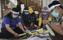 Local community health center workers in their off time assemble face shields to be distributed to co-workers as a precaution against the spread of the coronavirus outbreak in Jakarta, Indonesia Thursday, June 4, 2020. (AP Photo/Achmad Ibrahim)