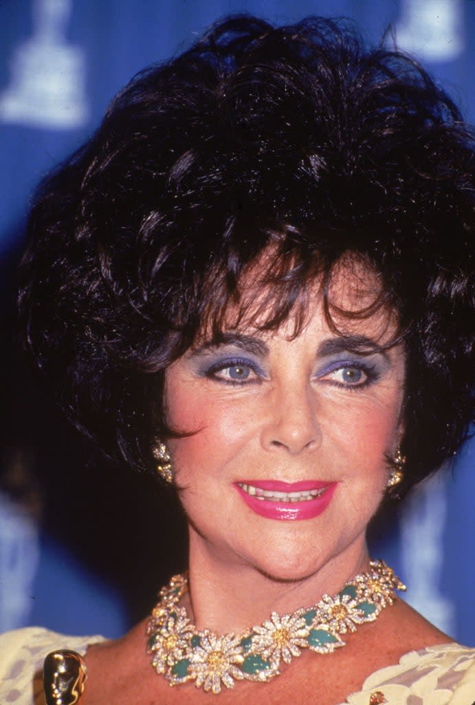 Close-up of Elizabeth Taylor with voluminous hair and a floral necklace