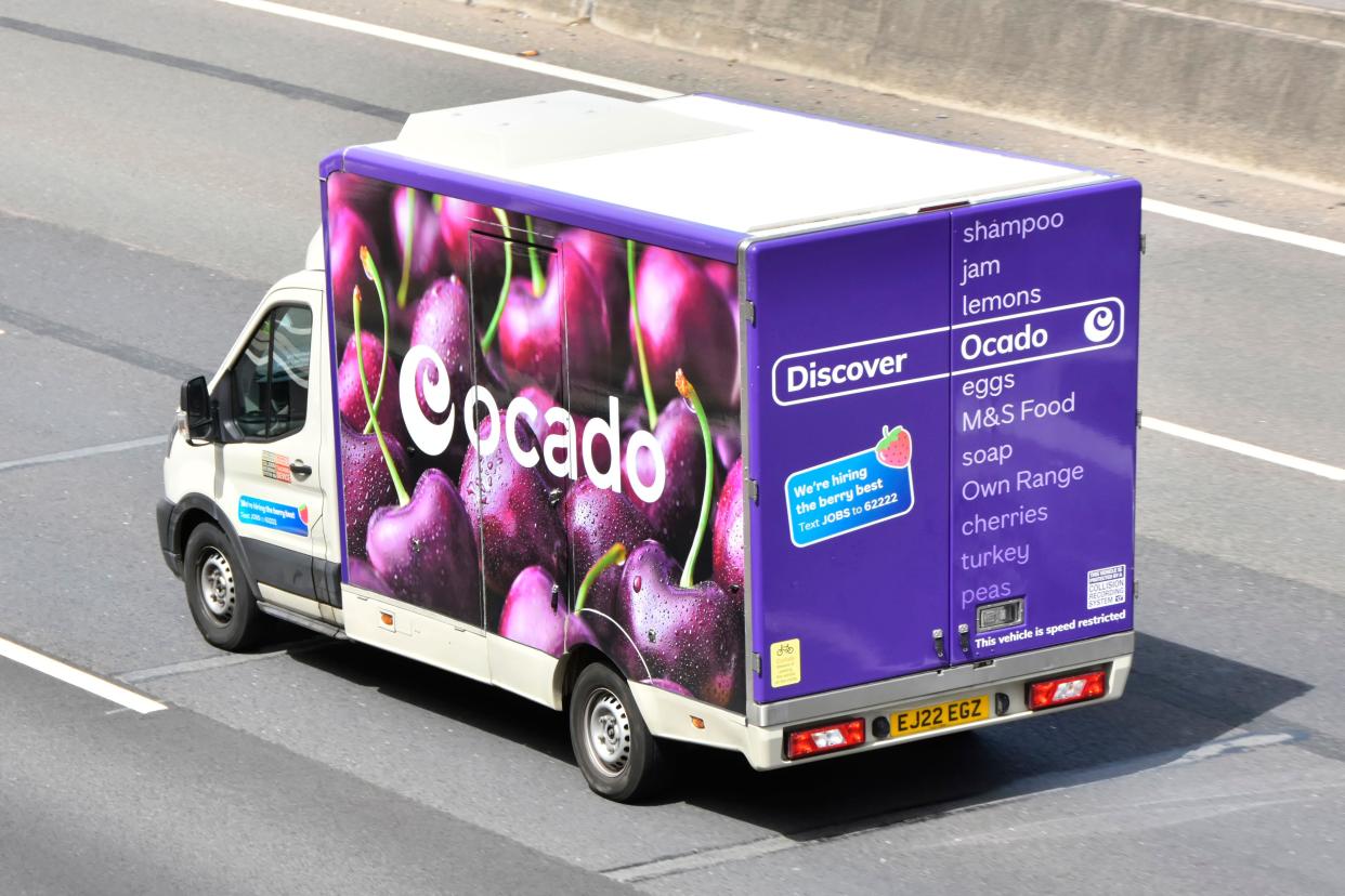 Side back rear & roof aerial view from above looking down colourful Ocado online grocery food shopping delivery van & logo driving English UK motorway