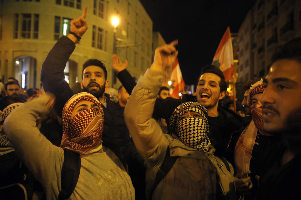 Anti-government demonstrators chant slogans during a protest at a road leading to the parliament building in Beirut, Lebanon, Thursday, Jan. 16, 2020. Lebanese protesters Thursday decried security forces' use of violence during rallies over the past two days, including attacks on journalists and the detention of over 100 people. (AP Photo/Bilal Hussein)