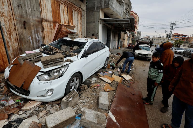 Palestinos inspeccionan el lugar de un ataque israelí contra una casa en Ráfah