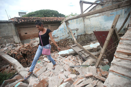 Peregrina, 26, an indigenous Zapotec transgender woman also know as Muxe, walks on the debris of her house destroyed after an earthquake that struck on the southern coast of Mexico late on Thursday, in Juchitan, Mexico, September 10, 2017. Picture taken, September 10, 2017. REUTERS/Edgard Garrido