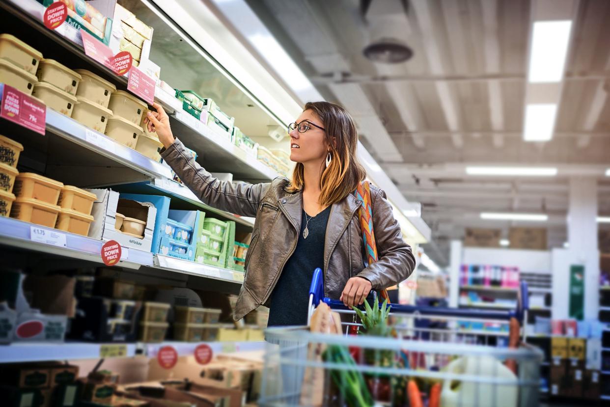 woman looking at butter section in grocery store