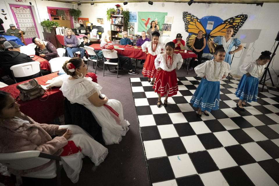 Niñas con trajes tradicionales del estado mexicano de Nuevo León actúan durante una celebración de posada, el domingo 17 de diciembre de 2023, en Fort Morgan, Colorado. Los organizadores ofrecieron una posada, una tradición latinoamericana basada en la historia bíblica sobre como María y José buscaban cobijo antes del nacimiento de Jesús, como forma de que los migrantes en Colorado sintieran una sensación de unidad durante las fiestas. (AP Foto/Julio Cortez)