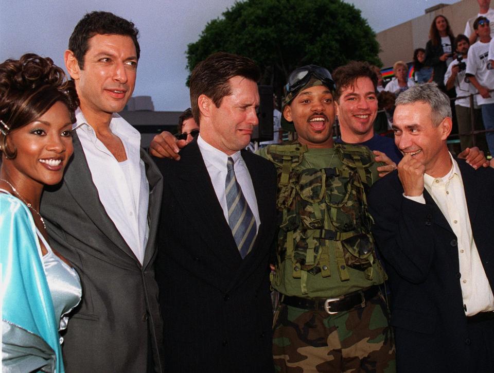 Will Smith, wearing military fatigues, star of "Independence Day" poses for a photo with fellow cast members, from left to right, Vivica Fox, Jeff Goldblum, Bill Pullman, Smith, singer Harry Connick Jr., and German director/executive producer/co-creator Roland Emmerich during the film's premiere in the Westwood section of Los Angeles Tuesday, June 25, 1996. (AP Photo/Kevork Djansezian)