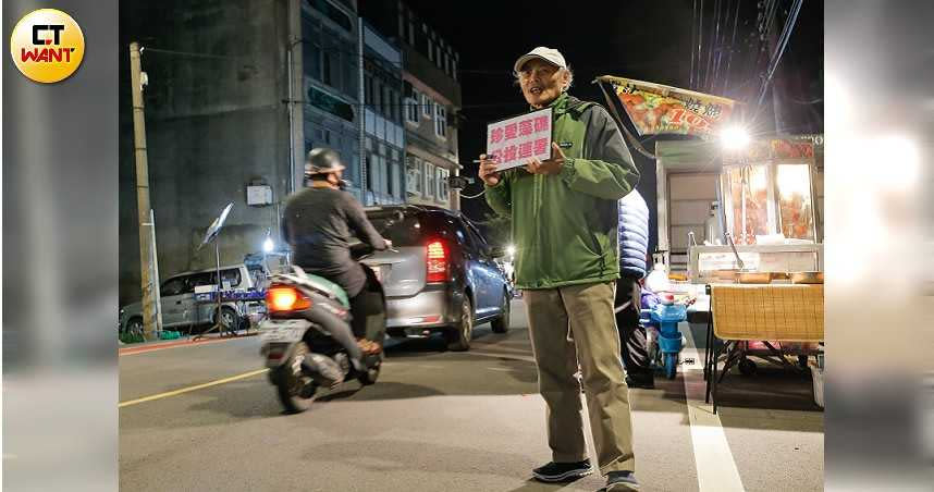 搶救大潭藻礁行動聯盟召集人潘忠政不畏寒風，赴桃園觀音夜市，舉標語招呼民眾連署反開發大潭藻礁，堅毅的眼神更顯無比的決心。（圖／黃耀徵攝）