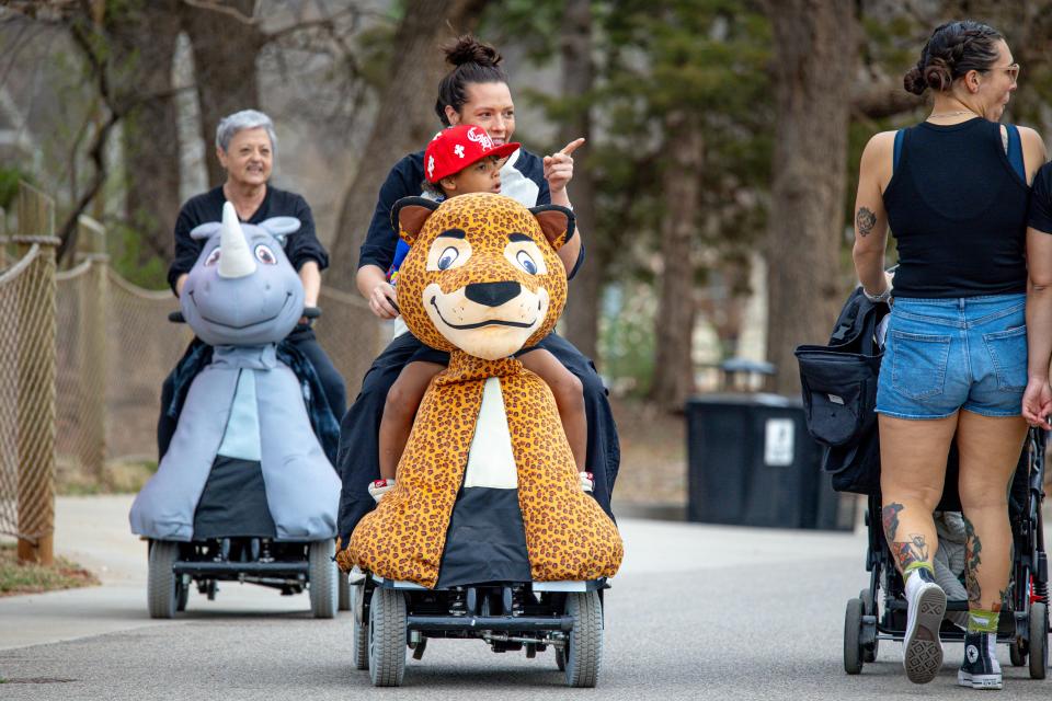 Rocky Reader and Tori Browning ride on ScooterPals on Feb. 27 at the Oklahoma City Zoo.