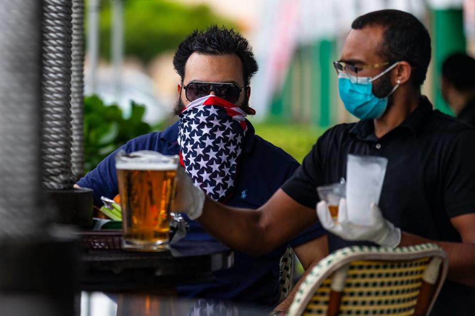 Chris Winokur, 39, orders a beer at FlaniganÕs in Kendall on the first day Miami-Dade County allowed restaurants to reopen their dining rooms on Monday, May 18, 2020. In order to control the spread of the coronavirus, Miami officials prohibited restaurants from operating their dining rooms on March 16, 2020.