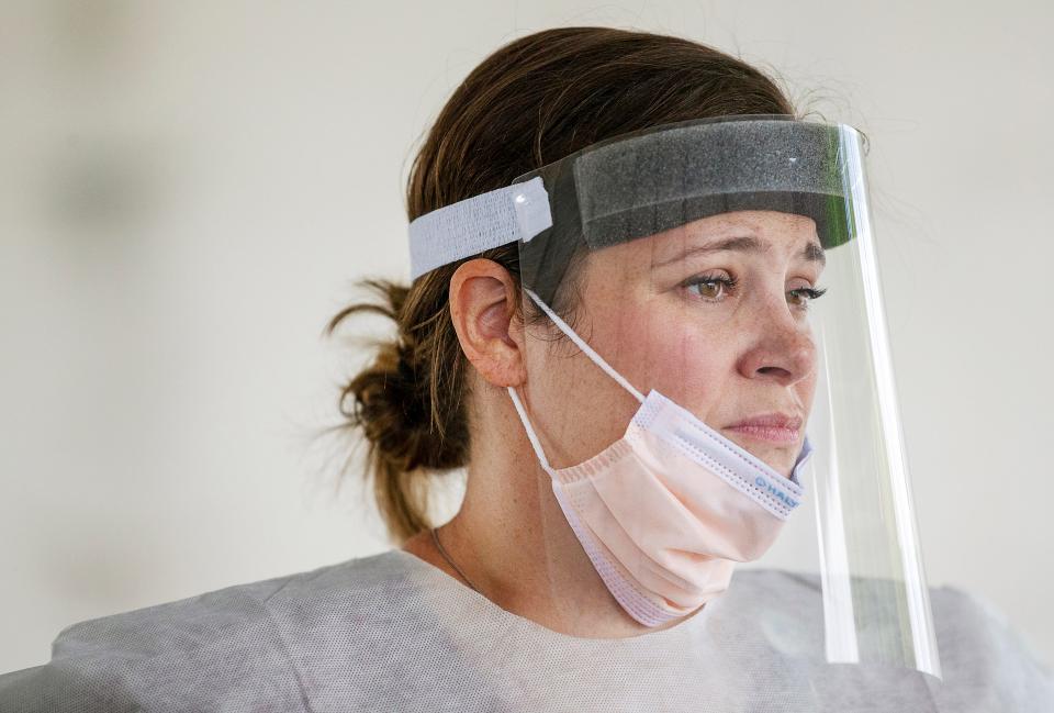 After comforting a woman she swabbed for COVID-19 testing, registered nurse Jenna Puckett takes a momentary rest before resuming testing at a mobile site in Cape Coral, Fla. "She was afraid and overwhelmed," Puckett said of the woman she tested. "She just needed someone to listen."