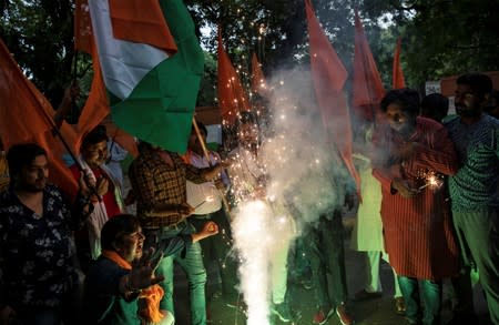 People burn firecrackers as they celebrate after the government scrapped the special status for Kashmir, in New Delhi