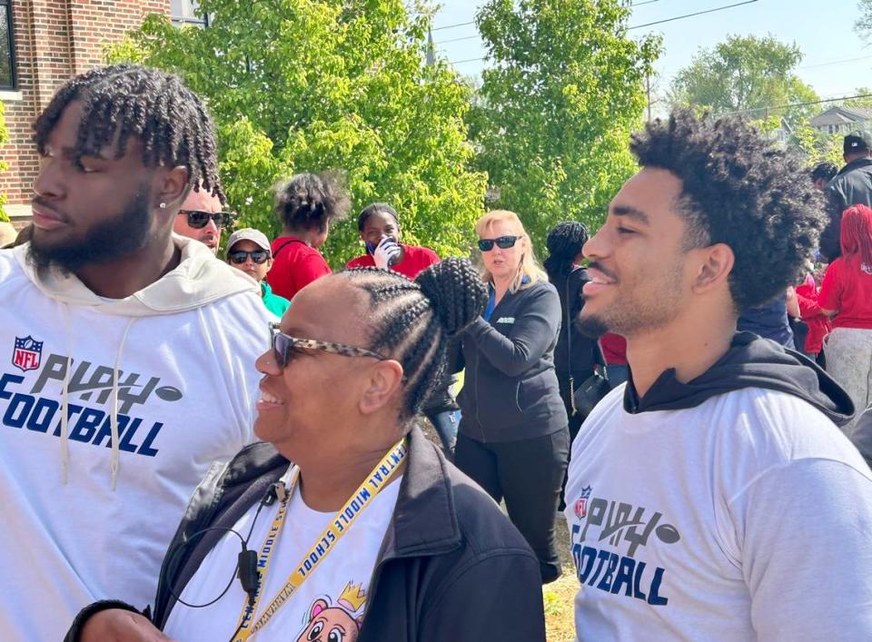Bryce Young (right) and Will Anderson Jr. (left), who were college teammates at Alabama, take a selfie with a school employee from Central Middle School in Kansas City, Mo., on Wednesday, April 26, 2023.