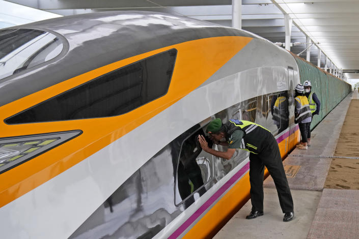 A soldier peeks into a newly-unveiled Comprehensive Inspection Train (CIT) unit at the Jakarta-Bandung Fast Railway station in Tegalluar, West Java, Indonesia, Thursday, Oct. 13, 2022. The 142-kilometer (88-mile) high-speed railway worth $5.5 billion is being constructed by PT Kereta Cepat Indonesia-China, a joint venture between an Indonesian consortium of four state-owned companies and China Railway International Co. Ltd. The joint venture says the trains that will be the fastest in Southeast Asia. (AP Photo/Dita Alangkara)