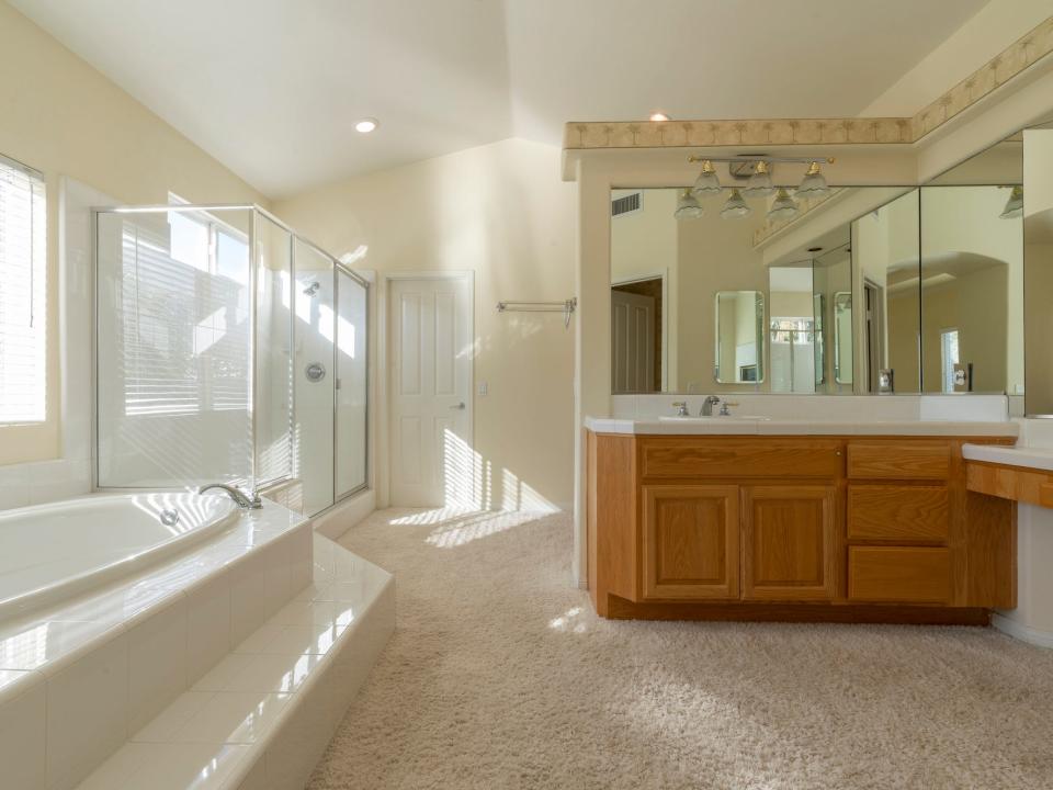 A yellow bathroom with a tub and shower.