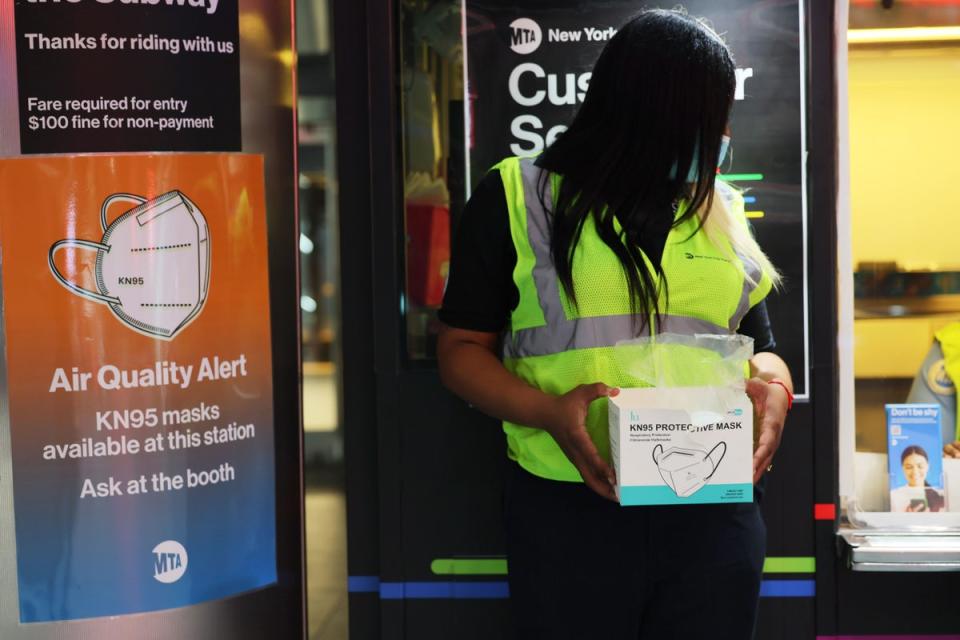 MTA employee Shanita Hancle offers masks to passengers at the Fulton Street subway station in Manhattan on 8 June (Getty Images)