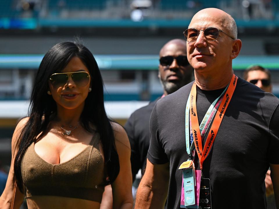 Jeff Bezos and Lauren Sanchez walk in the Paddock