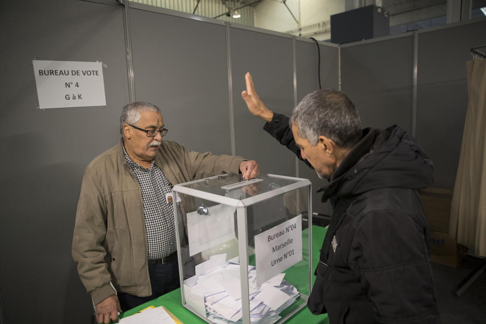 A Algerian voter casts his vote, Thursday, Dec.12, 2019, at the Algerian consulate in Marseille, southern France. Five candidates have their eyes on becoming the next president of Algeria in Thursday's contentious election boycotted by a massive pro-democracy movement. (AP Photo/Daniel Cole)