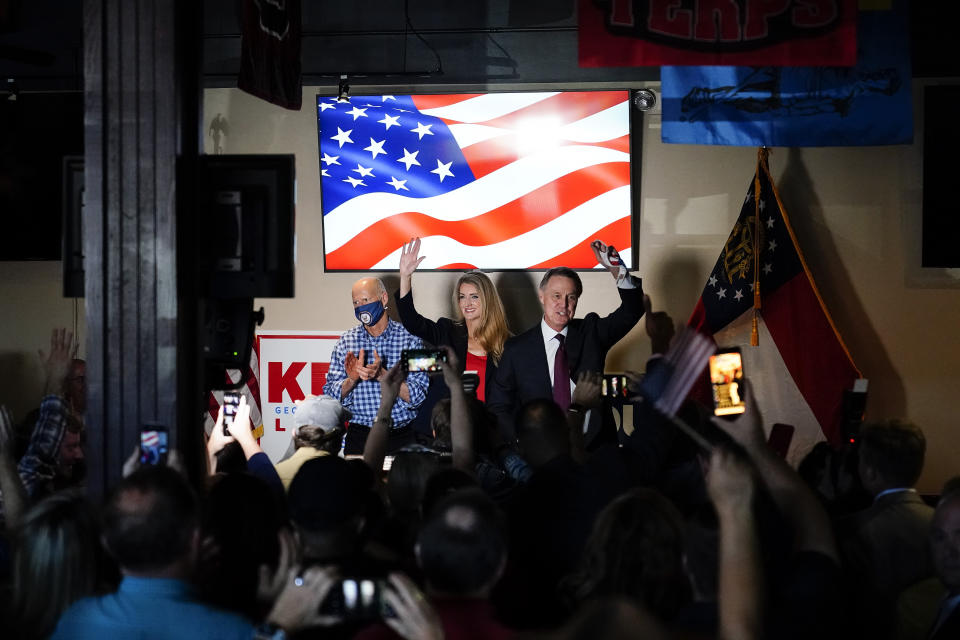 Sen. Rick Scott, R-Fla., left, Republican candidates for U.S. Senate Sen. Kelly Loeffler, center, and Sen. David Perdue wave to a crowd during a campaign rally on Friday, Nov. 13, 2020, in Cumming, Ga. (AP Photo/Brynn Anderson)