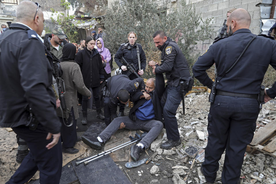 FILE - Israeli police officers detain a Palestinian during a protest supporting Palestinian families who are under threat of eviction from their longtime homes by Jewish settlers in the east Jerusalem neighborhood of Sheikh Jarrah, Dec. 17, 2021. Investigators commissioned by the U.N.-backed Human Rights Council said Tuesday, June 7, 2022, that tensions between Palestinians and Israelis are underpinned by a feeling that Israel has embarked on a “perpetual occupation” of Palestinian areas with no intention of ending it. The findings came in the first report by a Commission of Inquiry, set up last year following an 11-day war between Israel and Hamas in Gaza. (AP Photo/Mahmoud Illean, File)